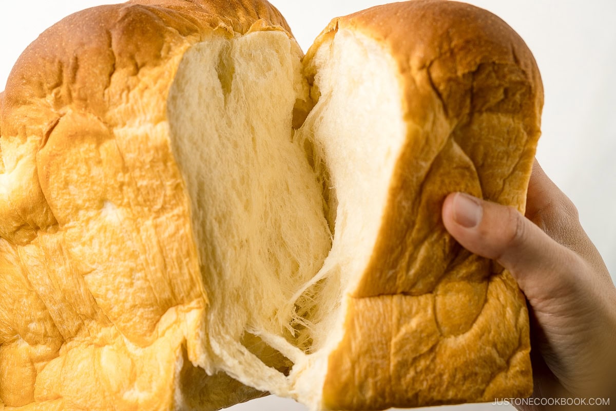 Japanese milk bread (Shokupan) being torn apart with hands.